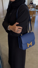 Model carrying the Bleu Saphir Herme$ Epsom Constance 18 shoulder bag