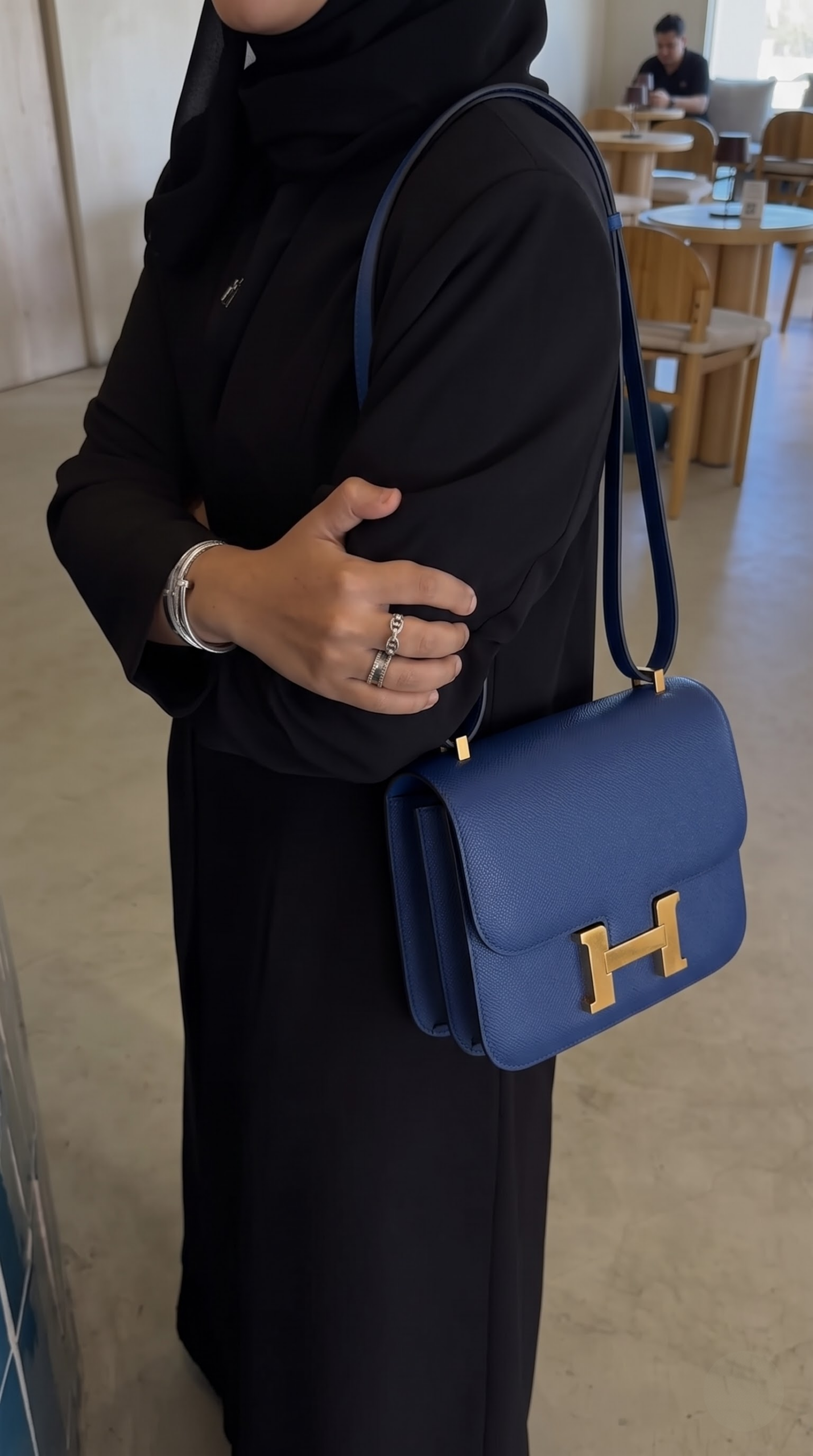 Model carrying the Bleu Saphir Herme$ Epsom Constance 18 shoulder bag