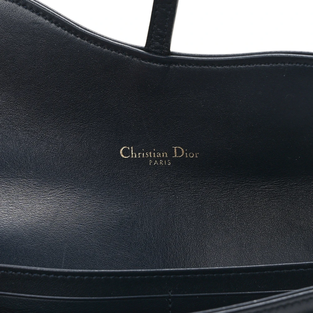 Close-up of the Saddle-inspired flap, brass-tone hardware, and chain strap on the D!0r long wallet