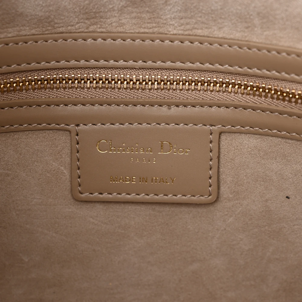 Close-up of the CD gold-tone buckles and Macrocannage quilting on the sand Diorcamp Messenger Bag