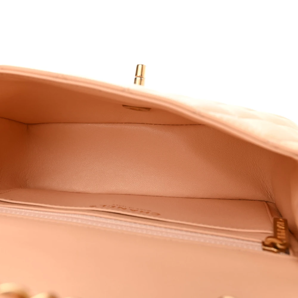 Interior view of the beige Ch@nel quilted Mini Flap showing the matching leather lining, zipper pocket, and patch pockets