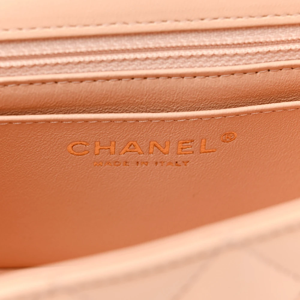 Close-up of the gold-tone CC turn-lock and chain-link shoulder strap on the beige Ch@nel quilted Mini Flap