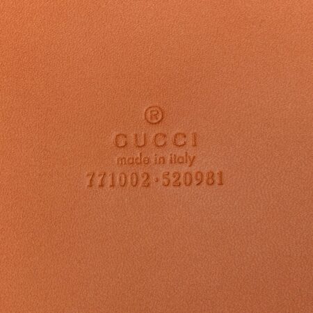 Close-up of the GG embossed detailing and diamond cut-out motif on the harness brown Gucc! Duffle Bag