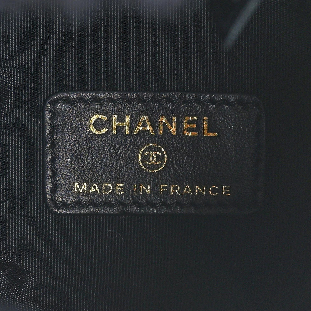 Close-up of the CC emblem, cinch cord, and gold-tone hardware on the black denim Mood Mini Bucket Bag
