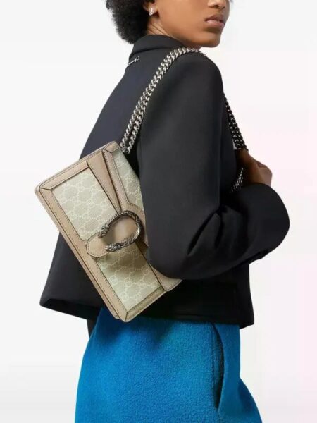 Model carrying the beige and white GG Dionysus Shoulder Bag with chain shoulder strap