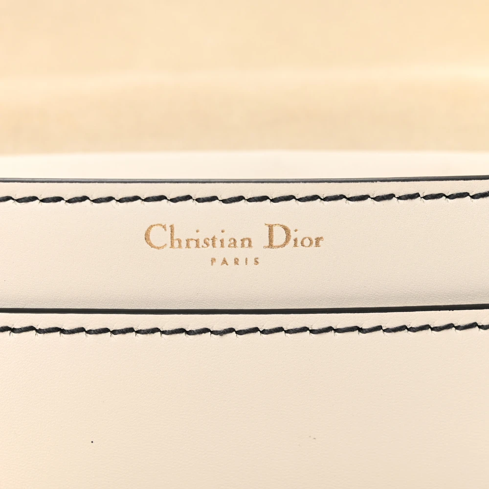 Close-up of gold-tone J’Adior signature and chain hardware on the off-white flap bag