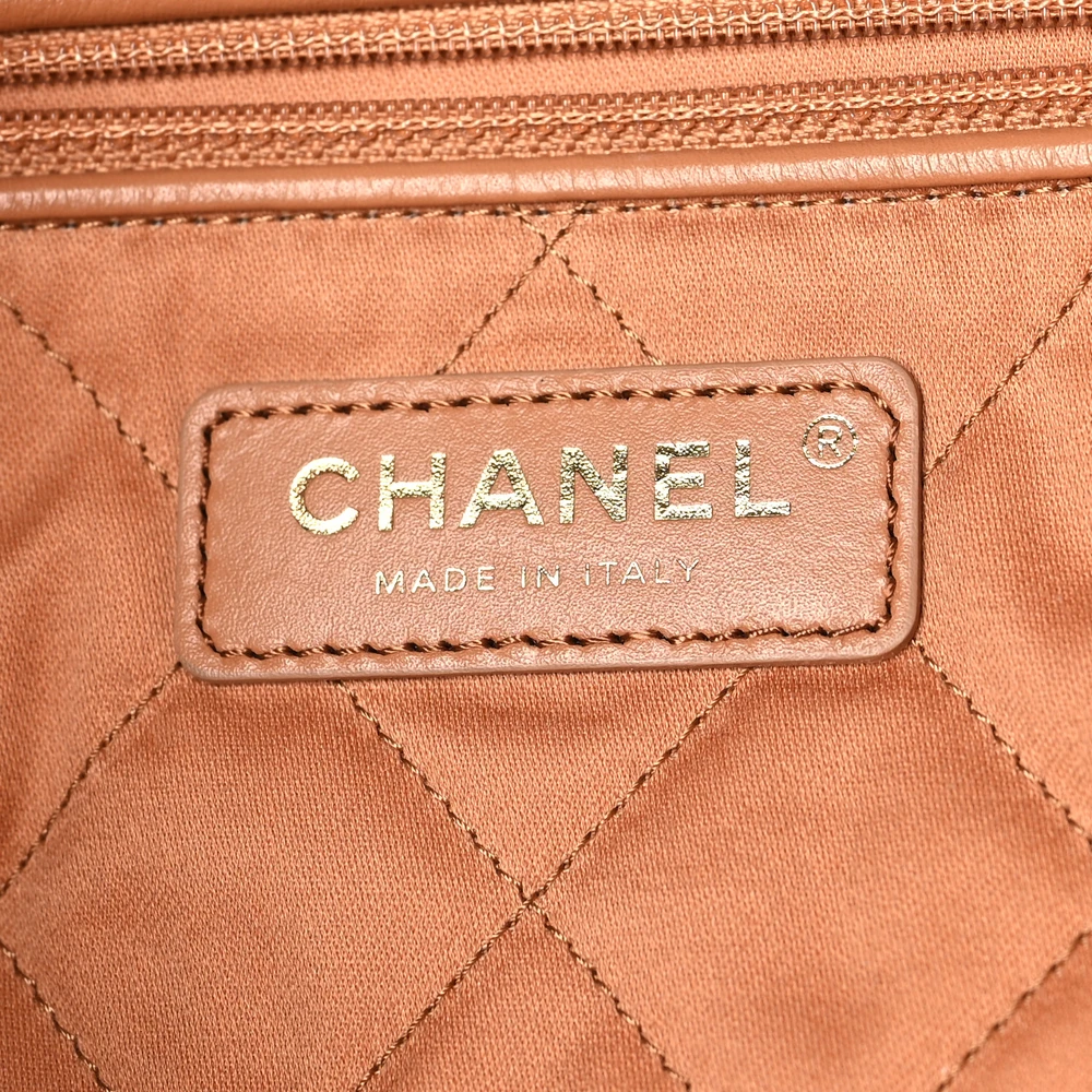 Close-up of the CC logo and leather-threaded gold-tone chain on the camel Ch@nel 22 bag