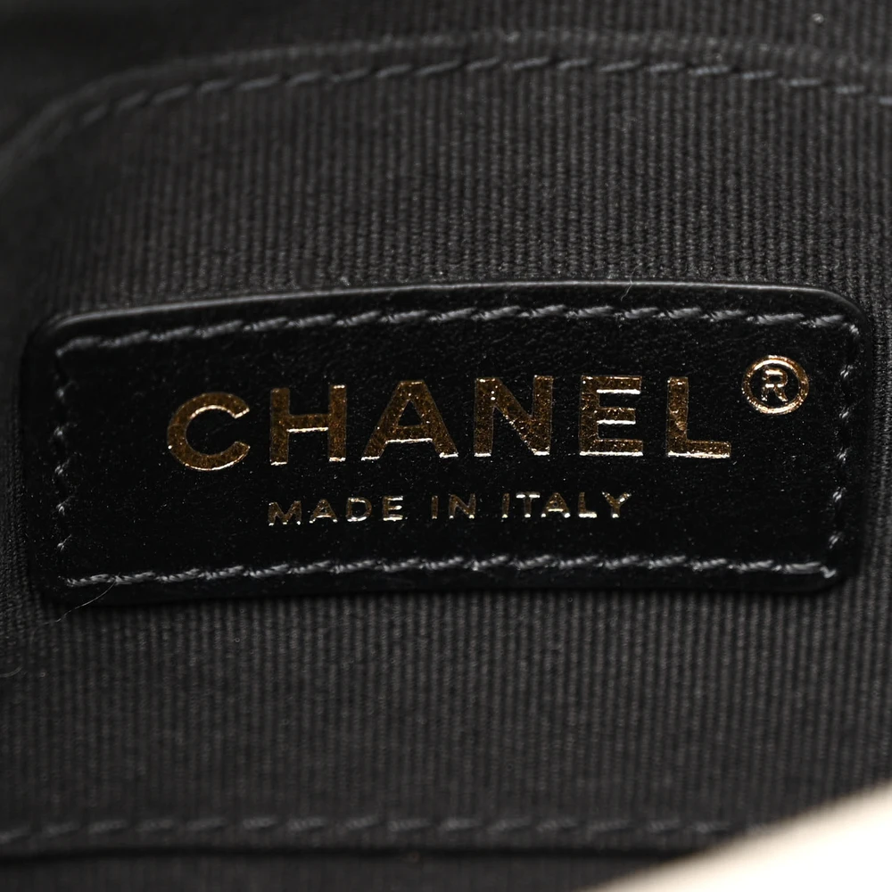 Close-up of the gold-tone turn-lock and medallion detail on the white flap bag