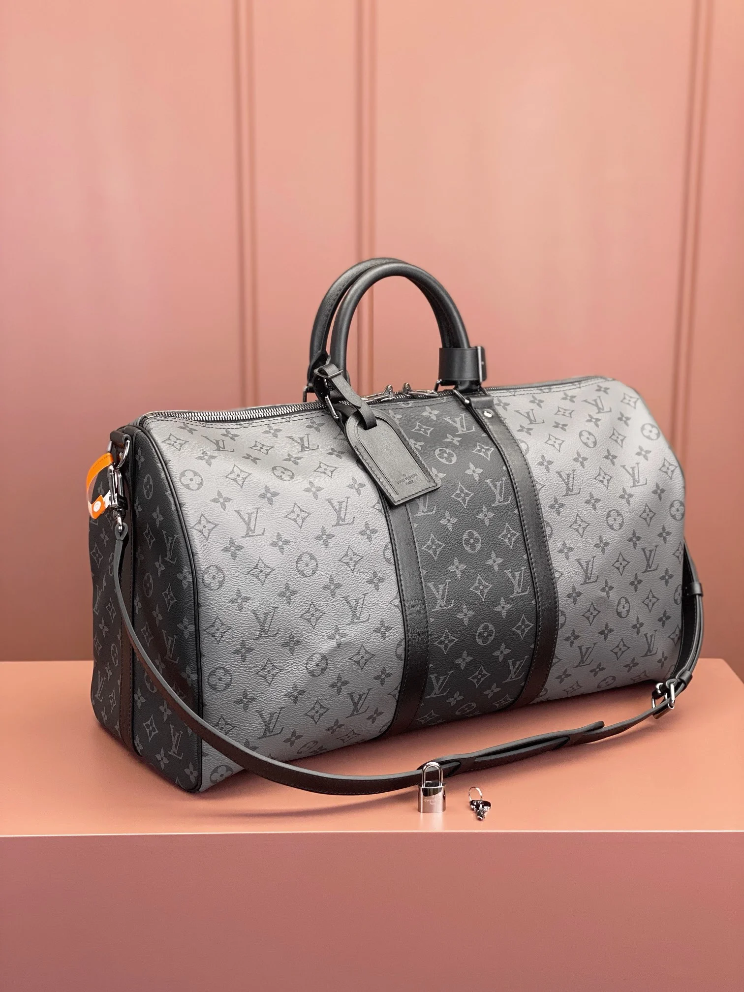 side view of the Lou!S Vuiton Keepall Bandoulière 50 in alternating dark and light grey Monogram Eclipse canvas