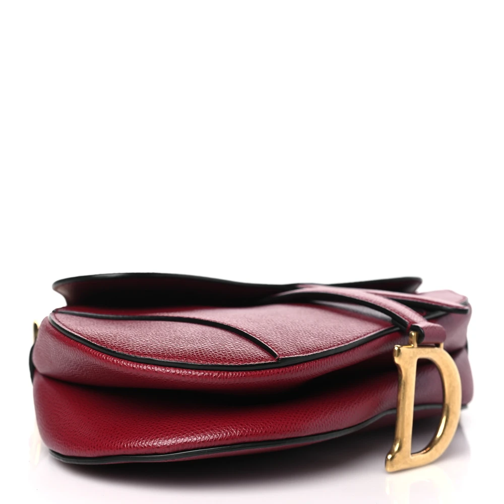 Bottom view of the red D!0r Saddle Bag with iconic curved silhouette and magnetic D stirrup clasp