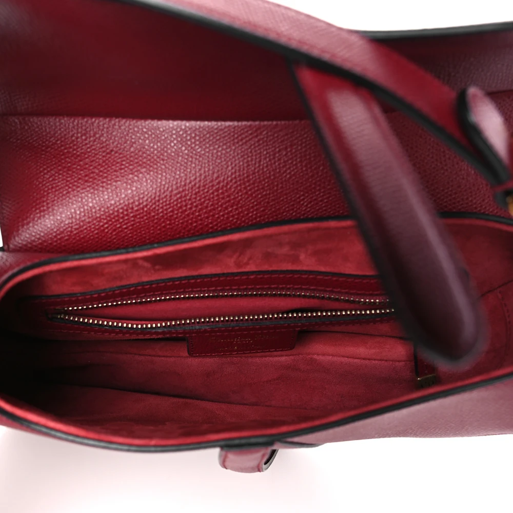 Interior of the red D!0r Saddle Bag with suede lining and zip pocket