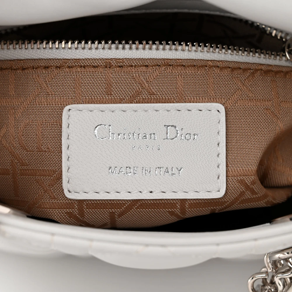 Close-up of the silver-tone D.I.O.R. charms and hardware on the white D!0r Mini Lady Bag