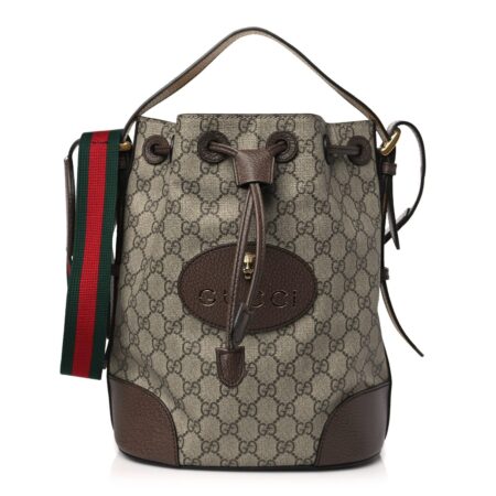 Front view of the beige Gucc! Neo Vintage Drawstring Bucket Backpack with GG monogram canvas and brown leather trim