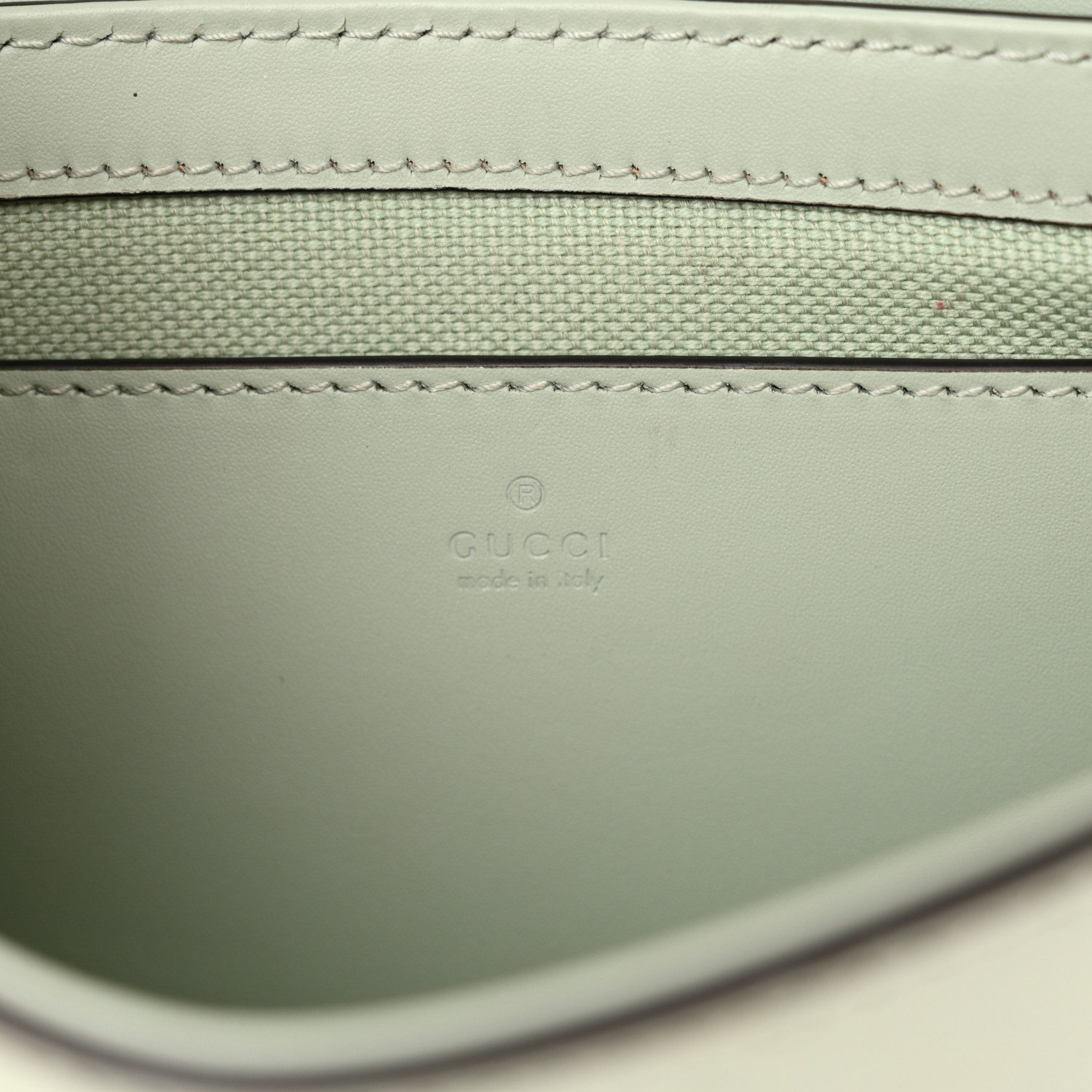 Close-up of the embossed GG detailing on the pale green Gucc! Super Mini Shoulder Bag