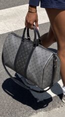 Model carrying the Lou!S Vuiton Keepall Bandoulière 50 with its adjustable shoulder strap