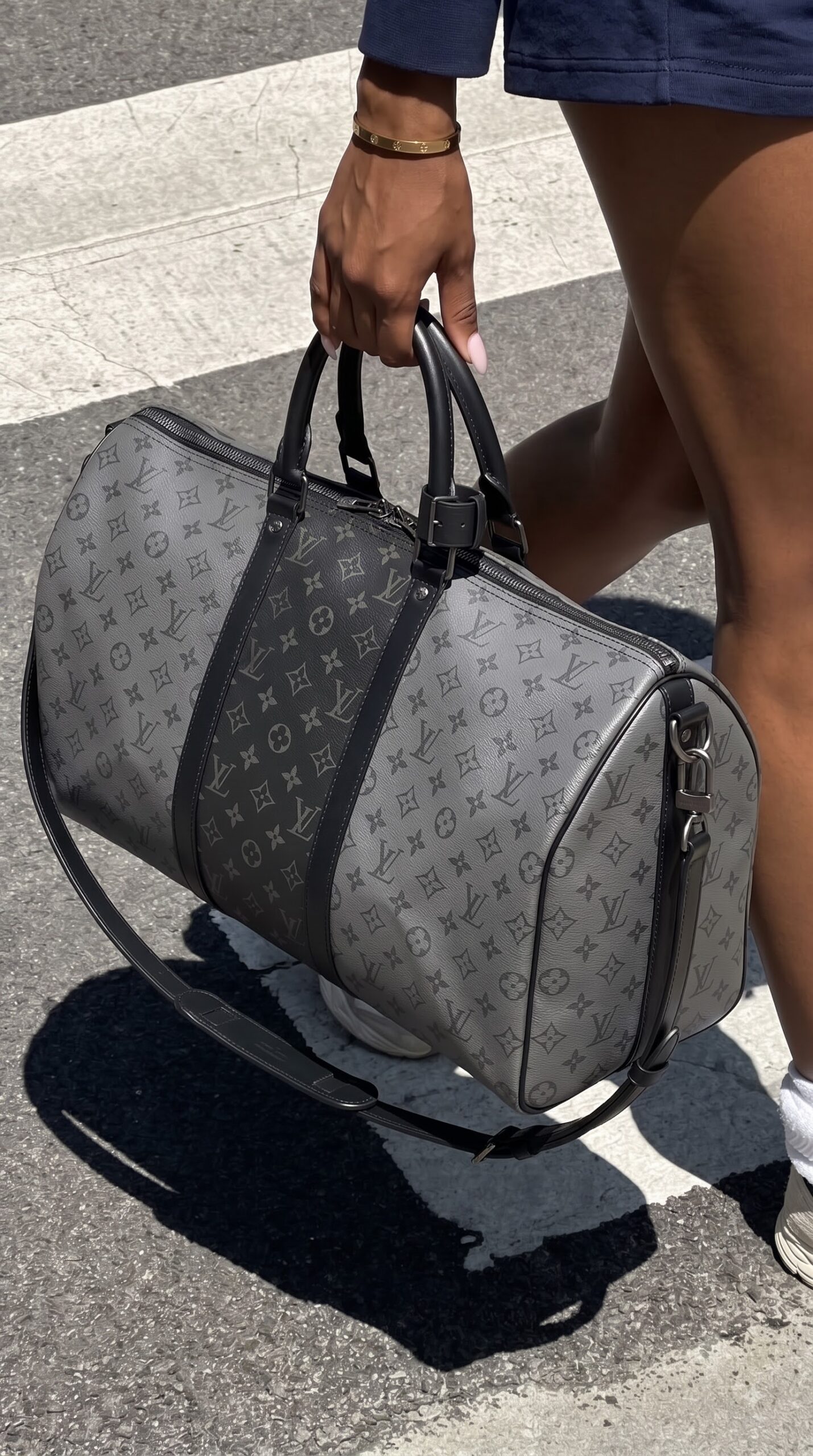 Model carrying the Lou!S Vuiton Keepall Bandoulière 50 with its adjustable shoulder strap
