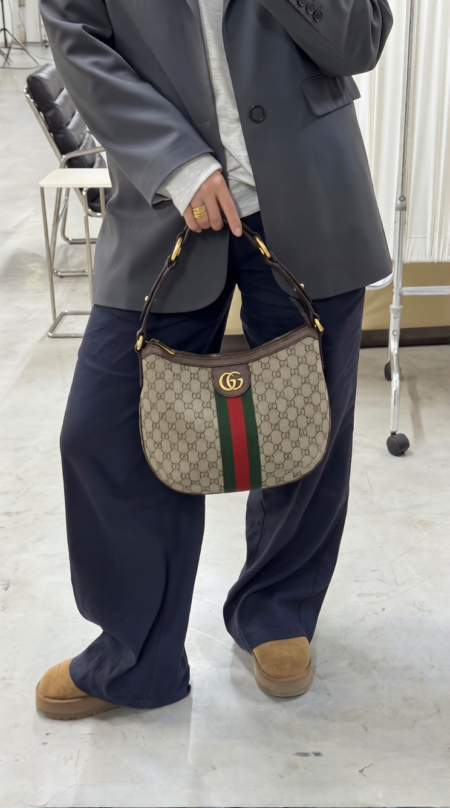 Model carrying the brown Gucc! Ophidia Half Moon Hobo over the shoulder