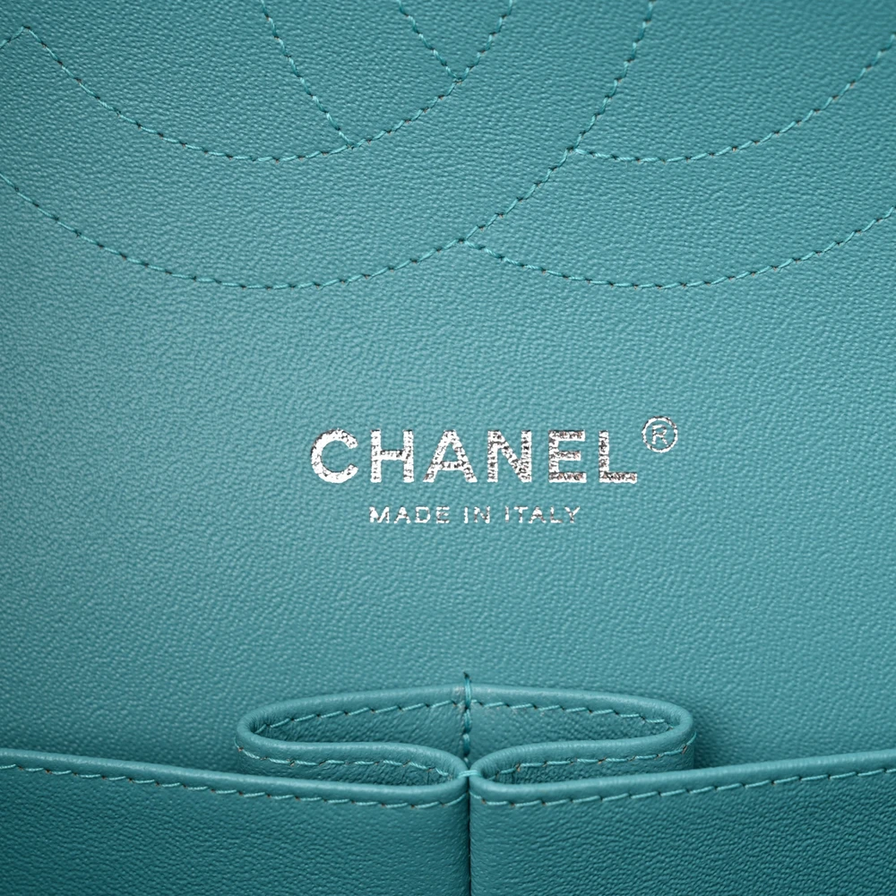 Close-up of the silver-tone CC turn-lock and chain hardware on the turquoise flap bag