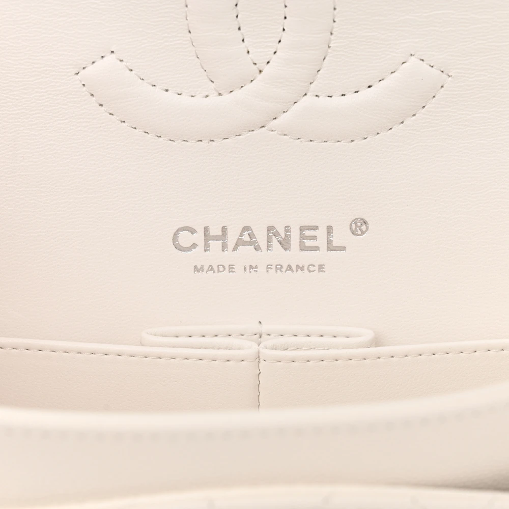 Close-up of the silver-tone CC turn-lock on the white quilted flap bag