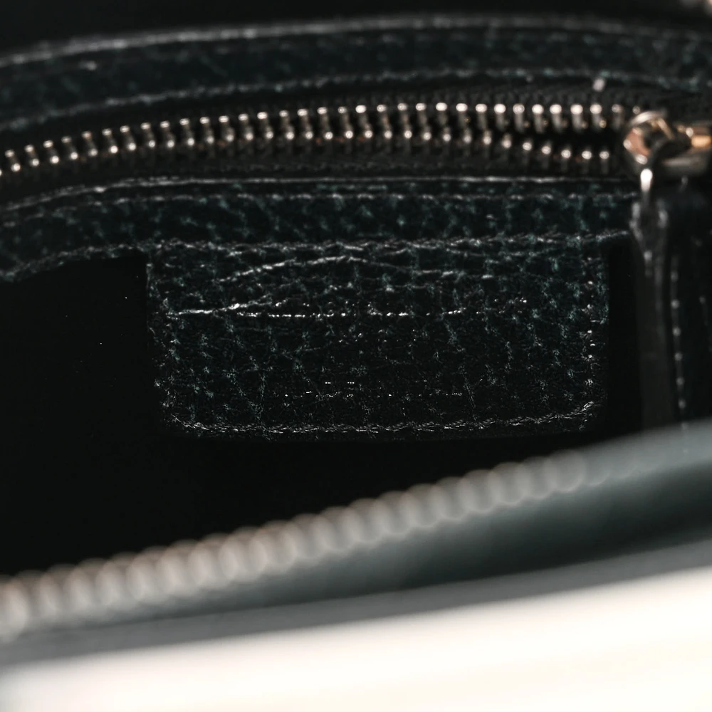 Close-up of the hanging Dior charm and silver-tone hardware on the dark green Lady D!0r bag