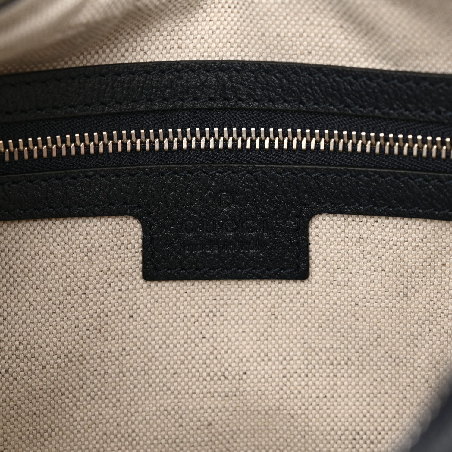 Close-up of the G-shaped hook closure on the beige and blue Gucc! Attache Large Shoulder Bag