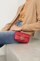 Model wearing the red Gucc! Super Mini GG Marmont Shoulder Bag with chain handle