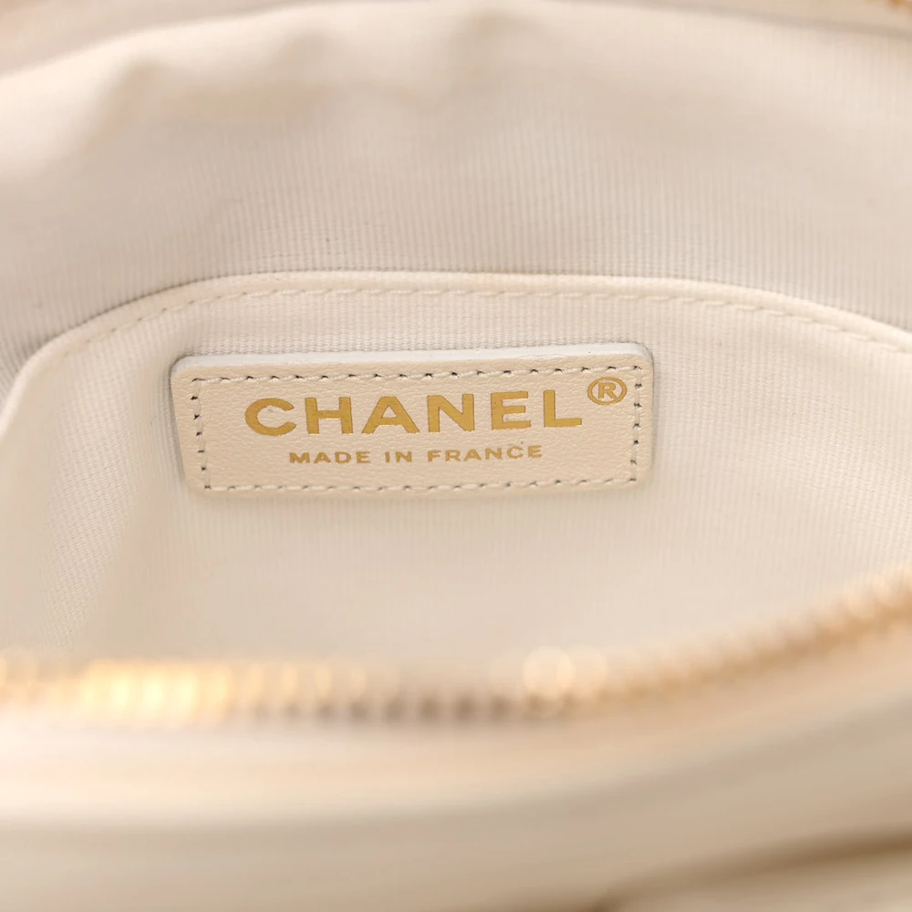 Close-up of the CC detail and gold-tone hardware on the white Camera Case bag