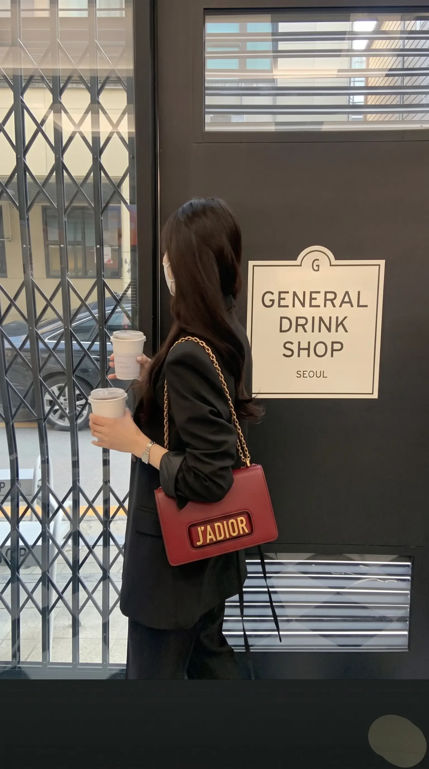 Model carrying the red D!0r J’Adior Chain Flap Bag with removable chain strap