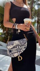 Model wearing the blue D!0r Saddle Bag crossbody with embroidered Around the World motif