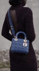 Model carrying the SuperFake blue Royale D!0r small Lady Bag with removable shoulder strap